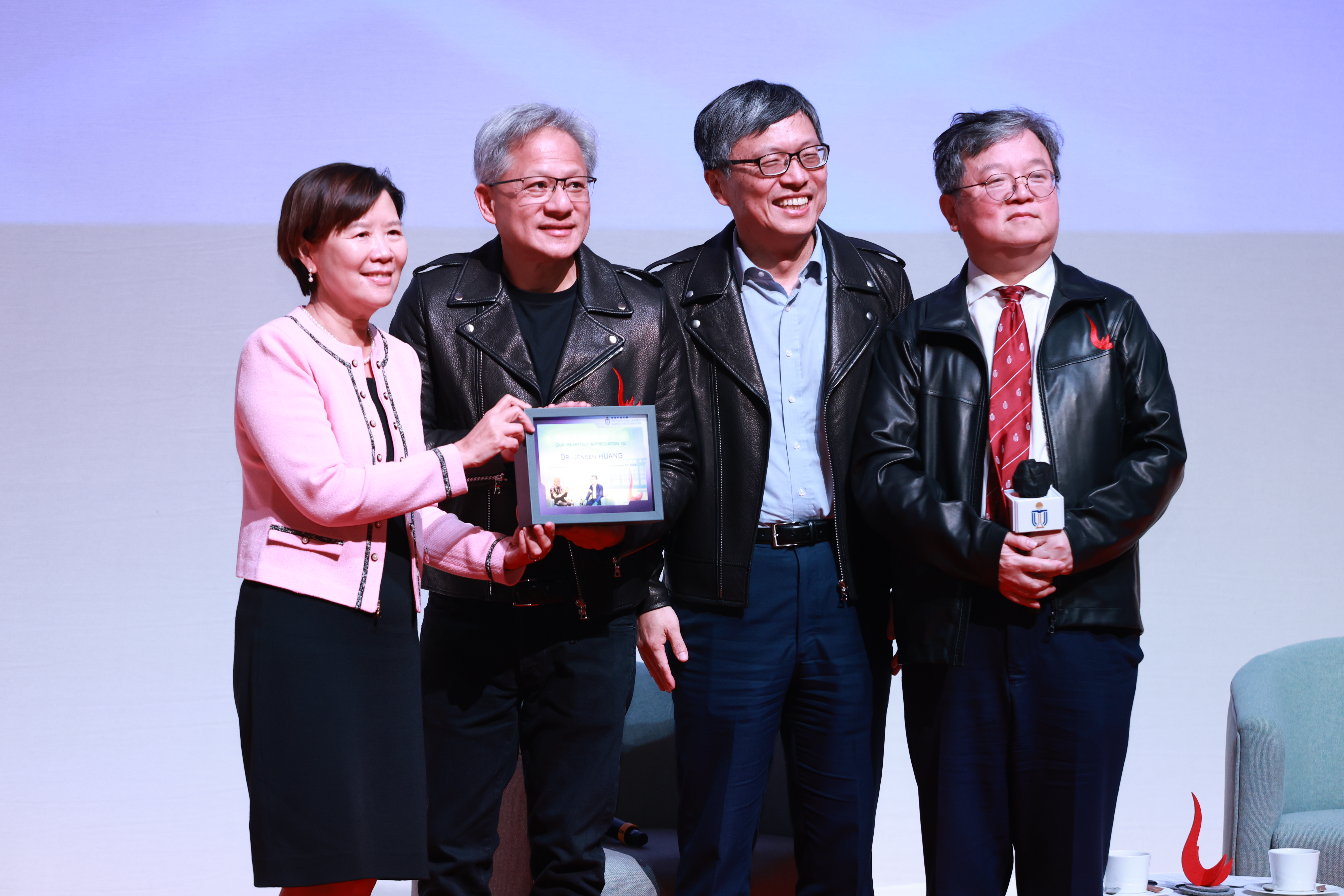 科大校长叶玉如教授（左一）、校董会主席沈向洋教授（右二）、首席副校长郭毅可教授（右一）向黄仁勋博士致送纪念品，以表谢意。