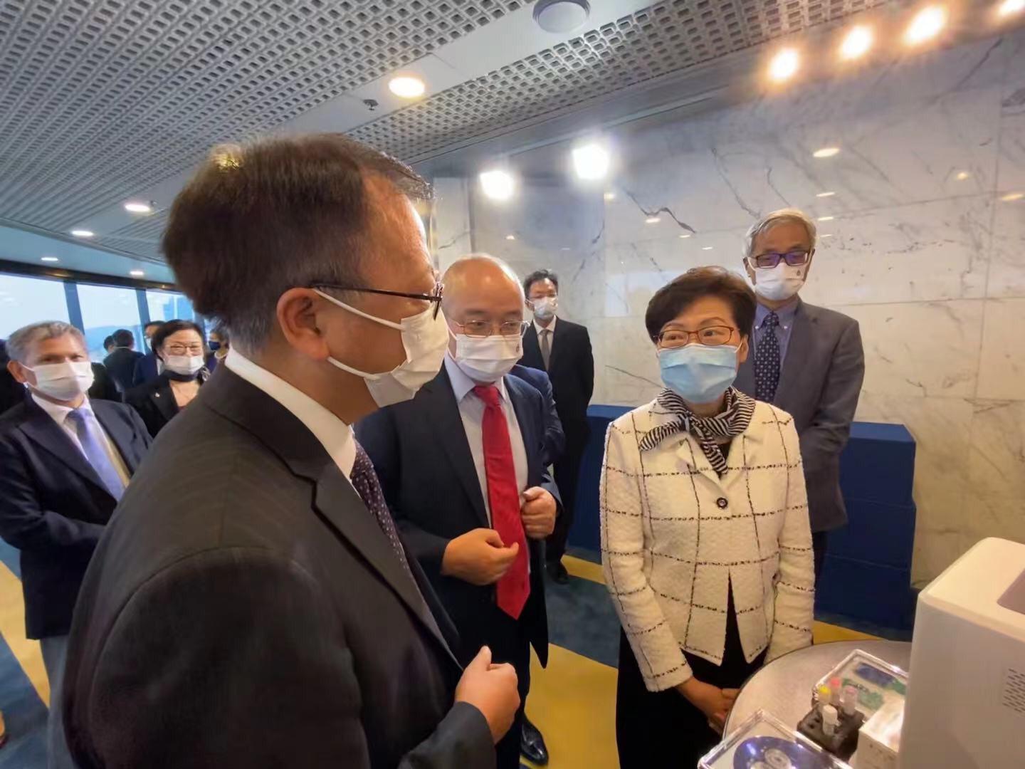 Prof. Wen Weijia (left) showcases his portable detection device for COVID-19, an invention developed by him and his research team.