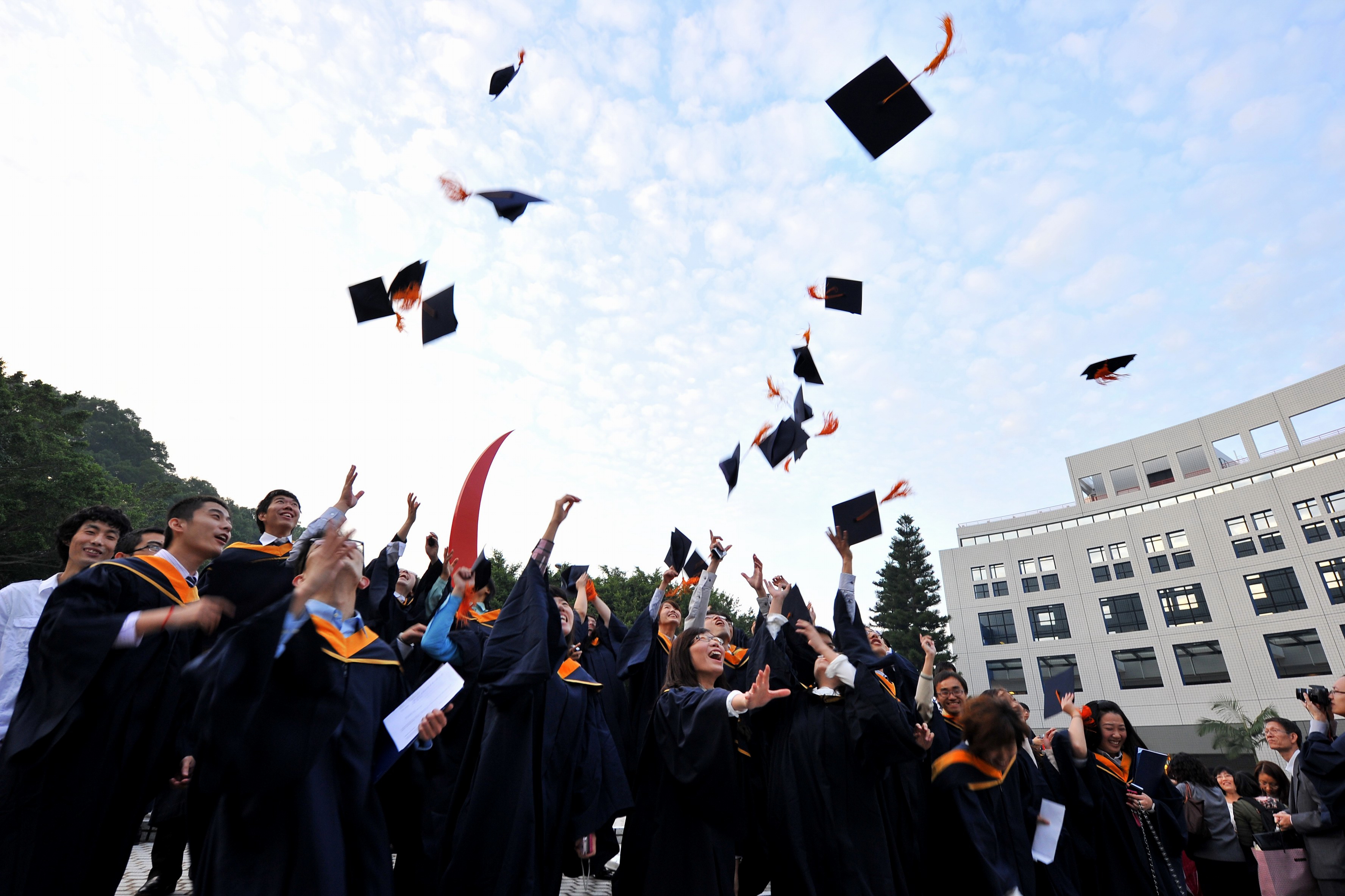 Graduates tossing their hats high in celebration.	