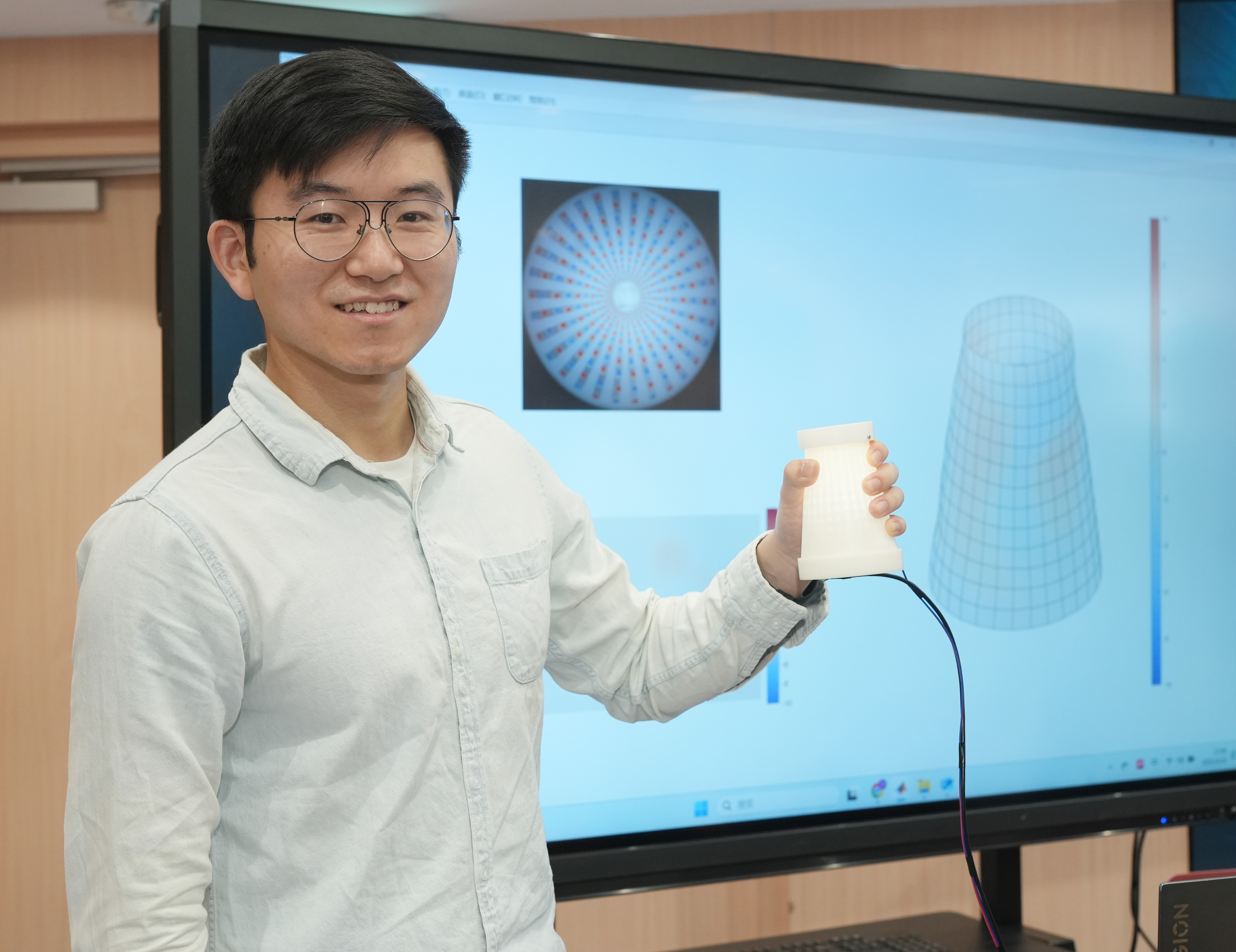  团队成员唐一峰展示AI手部触觉交互系统PhyTac。