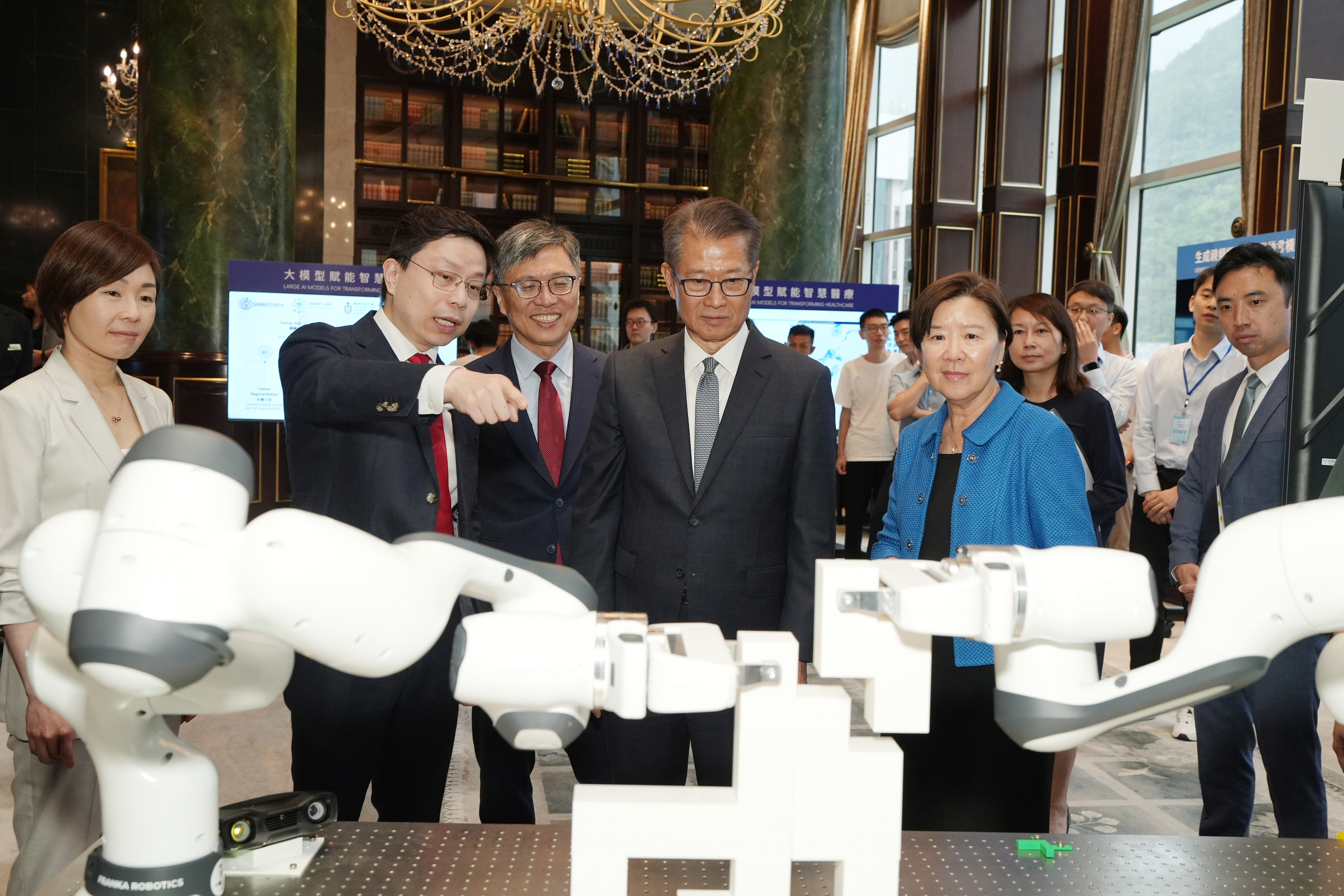 研究院院长贾佳亚教授向嘉宾展示由其团队设计的AI辅助机械臂协同智能装配工作系统。